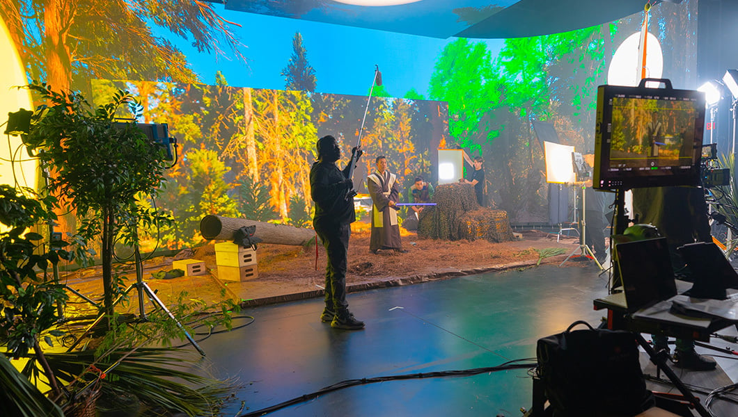 Full Sail’s Studio V1 soundstage is set up to look like the forest planet Endor from ‘Star Wars’ while crew and an actor dressed as a Jedi knight film a scene.